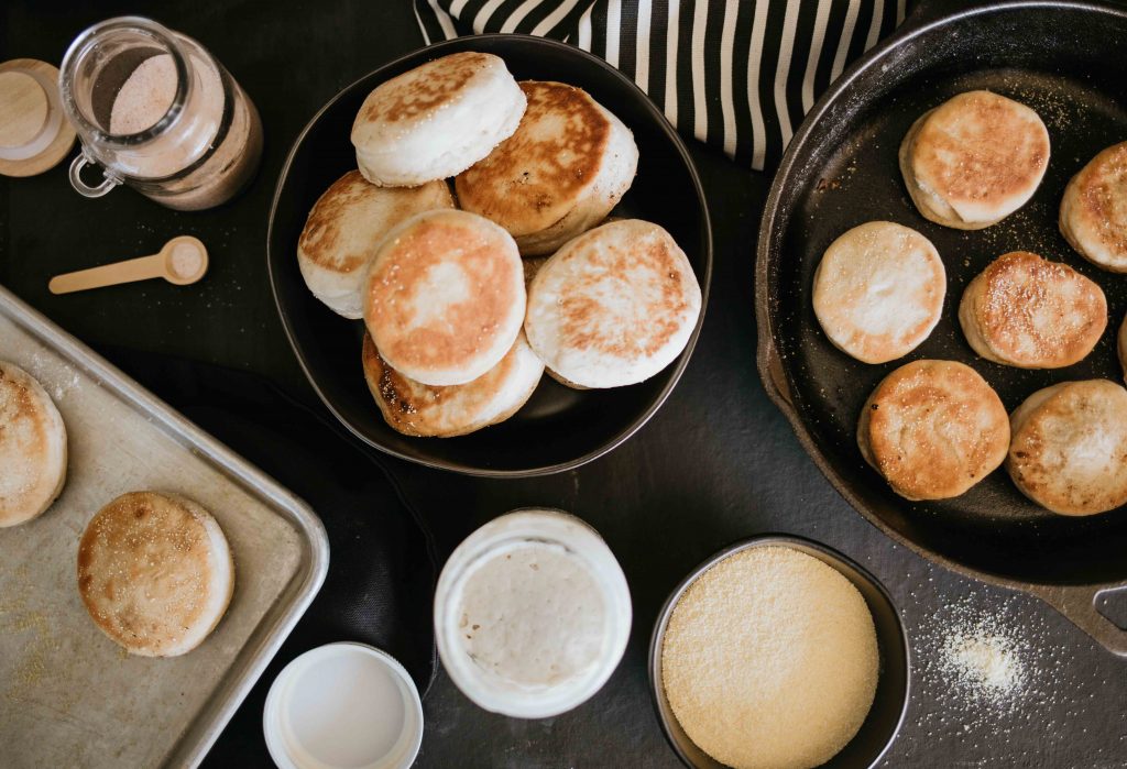 Piles of muffins in bowls and on trays. 